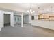 Open-concept living area features modern lighting, neutral carpet and seamless transition to kitchen at 5836 Spruce Creek Woods Dr, Port Orange, FL 32127