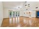 Bright living room with hardwood floors, ceiling fans and sliding glass doors to the outdoors at 5836 Spruce Creek Woods Dr, Port Orange, FL 32127