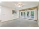 Bright living room with plush carpeting, neutral walls, and patio access through glass doors at 5836 Spruce Creek Woods Dr, Port Orange, FL 32127