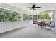 Screened-in porch featuring a ceiling fan and a table with chairs at 5836 Spruce Creek Woods Dr, Port Orange, FL 32127