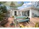 Serene backyard featuring a dining set with umbrella, brick paving, and lush greenery at 627 N Cherokee Ave, Deland, FL 32724