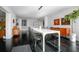 Open dining space with dark floors, mid-century modern decor and kitchen views at 627 N Cherokee Ave, Deland, FL 32724