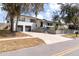 Charming two-story home with spacious driveway and lush, mature trees at 627 N Cherokee Ave, Deland, FL 32724