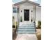 Inviting front entrance with well-manicured plants, decorative iron railings, and a freshly painted door at 627 N Cherokee Ave, Deland, FL 32724