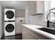 Practical laundry area with stacked washer/dryer, ample counter space, and neutral-toned cabinets at 627 N Cherokee Ave, Deland, FL 32724