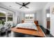 Bright main bedroom featuring hardwood floors, a ceiling fan, and large windows providing ample natural light at 627 N Cherokee Ave, Deland, FL 32724