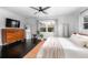 Sunlit main bedroom featuring a dresser, a mirror, light walls, and dark wood floors and a neutral color palette at 627 N Cherokee Ave, Deland, FL 32724