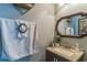 Charming powder room with decorative mirror, granite countertop, and cabinet with stylish towel and vanity decor at 636 Milan Dr, Kissimmee, FL 34758