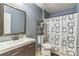 Bathroom featuring a modern sink, toilet, and shower with patterned curtain and storage shelves at 636 Milan Dr, Kissimmee, FL 34758