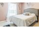Bright bedroom featuring a large window, soft lighting, and stylish gray upholstered headboard at 636 Milan Dr, Kissimmee, FL 34758
