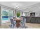 Bright dining area featuring a round table, stylish chairs, and sliding glass doors to the pool at 636 Milan Dr, Kissimmee, FL 34758
