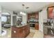 Well-lit kitchen featuring a center island, dark cabinets, stainless steel appliances, and an adjacent living space at 636 Milan Dr, Kissimmee, FL 34758