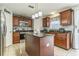 Modern kitchen with cherry cabinets, granite countertops, stainless steel appliances, and an island with seating at 636 Milan Dr, Kissimmee, FL 34758