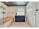 Clean and spacious bathroom with a bathtub, a small cabinet, and a window at 640 S Lake Formosa Dr, Orlando, FL 32803