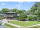 Stunning exterior showcasing a manicured lawn and a two-story home with balcony and dual garage at 640 S Lake Formosa Dr, Orlando, FL 32803