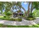 View of the home with a brick patio under a large tree, adding to the serene outdoor space at 640 S Lake Formosa Dr, Orlando, FL 32803