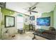 Bedroom featuring green walls, ceiling fan, weights, and couch at 6401 Fortune Ln, Apopka, FL 32712