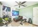 Bedroom featuring green walls, weights, ceiling fan, and couch at 6401 Fortune Ln, Apopka, FL 32712
