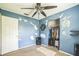Bedroom featuring blue walls, ceiling fan, and open closet at 6401 Fortune Ln, Apopka, FL 32712
