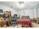 Bedroom featuring desk, large chair, dresser, and red plaid bedspread at 6401 Fortune Ln, Apopka, FL 32712