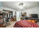 A spacious bedroom with a closet, a desk, a tv and a red and black plaid bedspread at 6401 Fortune Ln, Apopka, FL 32712