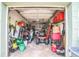 Spacious garage featuring ample storage with tools, equipment, and lawn care items at 6401 Fortune Ln, Apopka, FL 32712