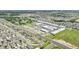 A wide aerial shot captures a suburban neighborhood, highlighting its neatly arranged homes and community facilities in a vast landscape at 785 Orchid Grove Blvd, Davenport, FL 33837