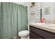 This bathroom includes a shower, green shower curtain, shelving and decorative wallpaper at 785 Orchid Grove Blvd, Davenport, FL 33837