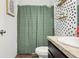 This bathroom includes a shower, green shower curtain, shelving and decorative wallpaper at 785 Orchid Grove Blvd, Davenport, FL 33837