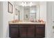 A vanity with a granite countertop, cabinets and a mirror provides ample storage in this bathroom at 785 Orchid Grove Blvd, Davenport, FL 33837