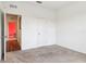 Bright, carpeted bedroom featuring neutral walls and an open doorway leading to the rest of the home at 785 Orchid Grove Blvd, Davenport, FL 33837