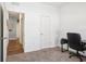 The bedroom has neutral carpet, a desk, black chair and white walls at 785 Orchid Grove Blvd, Davenport, FL 33837