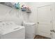 This functional laundry room features a washer, dryer, shelving and neutral paint at 785 Orchid Grove Blvd, Davenport, FL 33837