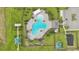 Aerial view of a community pool with lounge chairs, shade, a clubhouse, a playground, and ample green space at 785 Orchid Grove Blvd, Davenport, FL 33837