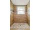 Walk-in shower featuring neutral colored stone tile flooring and stylish dark wood paneling at 841 Wesson Ct, Casselberry, FL 32707