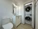 Bathroom with a modern vanity and stacked washer and dryer at 910 Flamingo Dr, Leesburg, FL 34748