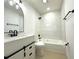 Modern bathroom features a white vanity, black hardware, and a shower over a tub with white subway tile at 910 Flamingo Dr, Leesburg, FL 34748