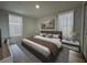 A bedroom with an abstract painting over the headboard, white sheer curtains, and two end tables with lamps at 910 Flamingo Dr, Leesburg, FL 34748
