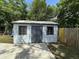 Exterior shot of a shed with a concrete slab in front and a partially-visible swing set in the background at 910 Flamingo Dr, Leesburg, FL 34748