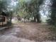 Expansive backyard with mature trees and a glimpse of a community pool in the distance at 4250 Lake Ave, Kissimmee, FL 34746