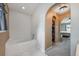 Bathroom with tub and view of the bedroom through an arched doorway with storage at 100 Monterey Oaks Dr, Sanford, FL 32771