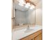 A vanity features a white countertop, sink, wooden cabinets, and a large mirror at 100 Monterey Oaks Dr, Sanford, FL 32771
