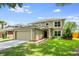 Two-story home with a two-car garage, manicured lawn, walkway, and neutral-colored stucco exterior at 100 Monterey Oaks Dr, Sanford, FL 32771