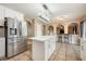Open kitchen featuring an island, stainless steel refrigerator, white cabinetry, tile floors, and pendant lighting at 100 Monterey Oaks Dr, Sanford, FL 32771