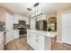 White kitchen with stainless appliances, island with quartz countertop and mosaic backsplash at 100 Monterey Oaks Dr, Sanford, FL 32771