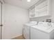 A clean, functional laundry room featuring a washer, dryer, and built-in shelving at 100 Monterey Oaks Dr, Sanford, FL 32771