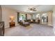 Open-concept living room with neutral carpet, a large sofa, and arched openings to other rooms at 100 Monterey Oaks Dr, Sanford, FL 32771