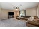 Cozy living room with a fireplace, large sectional sofa, neutral carpeting and plenty of natural light at 100 Monterey Oaks Dr, Sanford, FL 32771