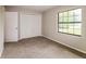 Comfortable carpeted bedroom with a closet and natural light from the window at 10448 Sw 74Th Ct, Ocala, FL 34476