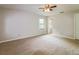Bright, carpeted bedroom with a ceiling fan and natural light from the window at 10448 Sw 74Th Ct, Ocala, FL 34476